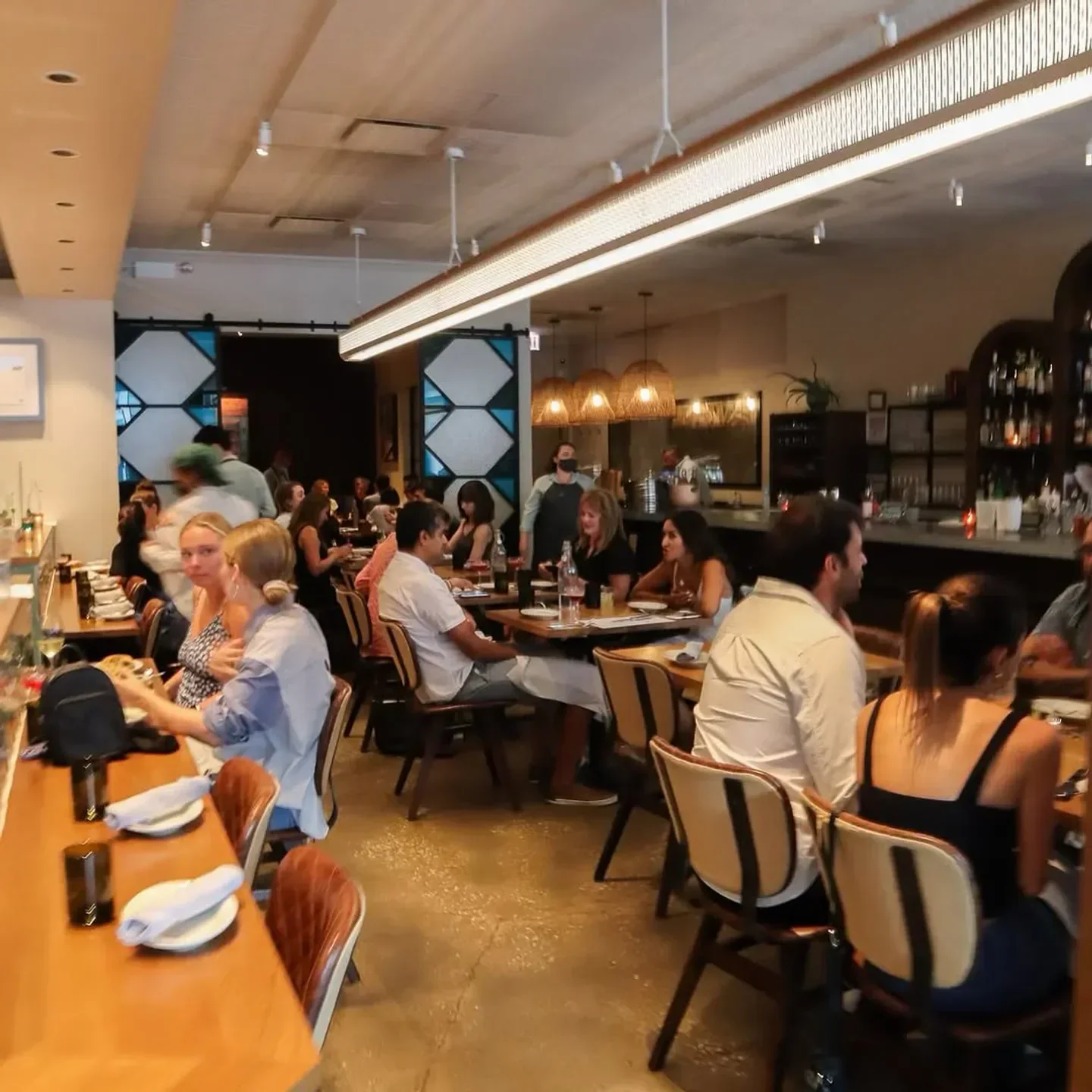 Busy dining room at Galit restaurant in Chicago with people enjoying meals.