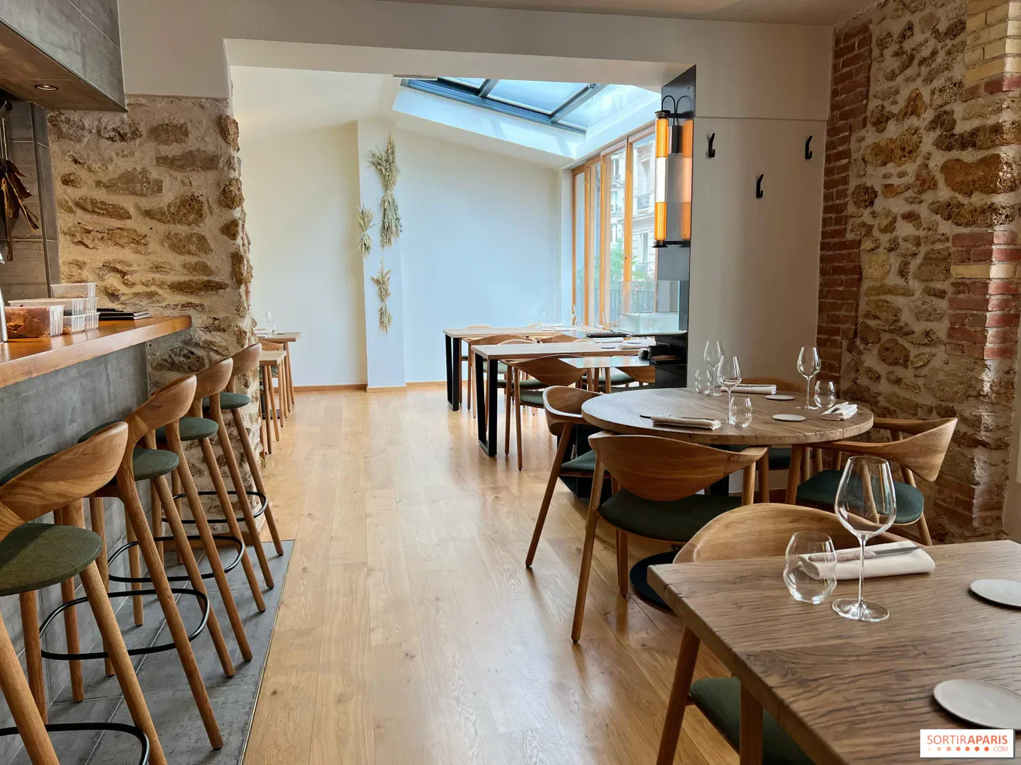 Interior of Géosmine restaurant in Paris, featuring wooden tables and a rustic atmosphere.
