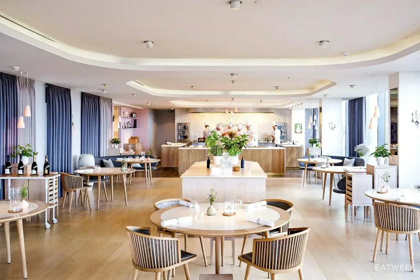 Elegant interior of Geranium restaurant in Copenhagen with a view of the open kitchen.