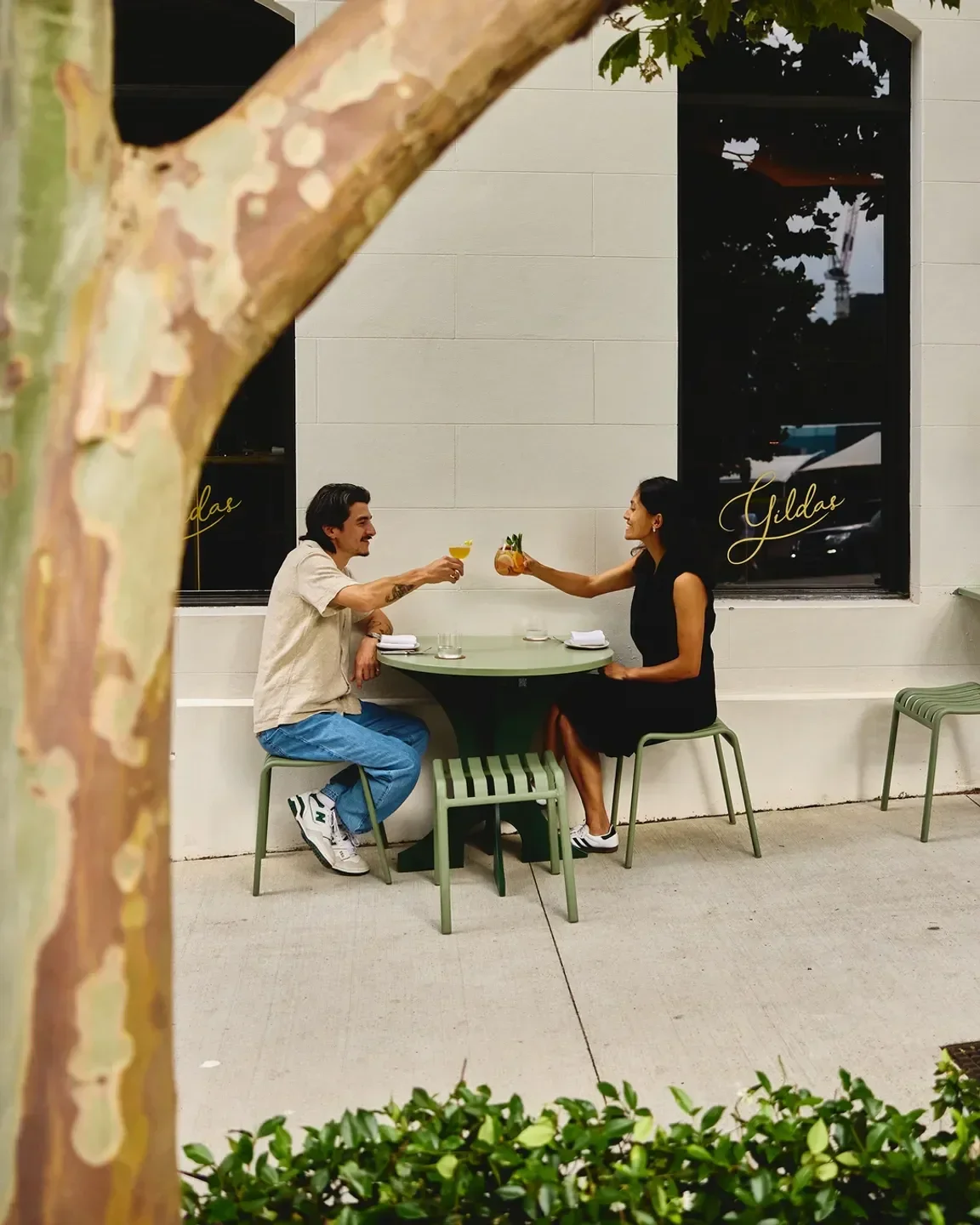 Couple toasting cocktails at Gildas restaurant in Sydney, enjoying a nice moment.