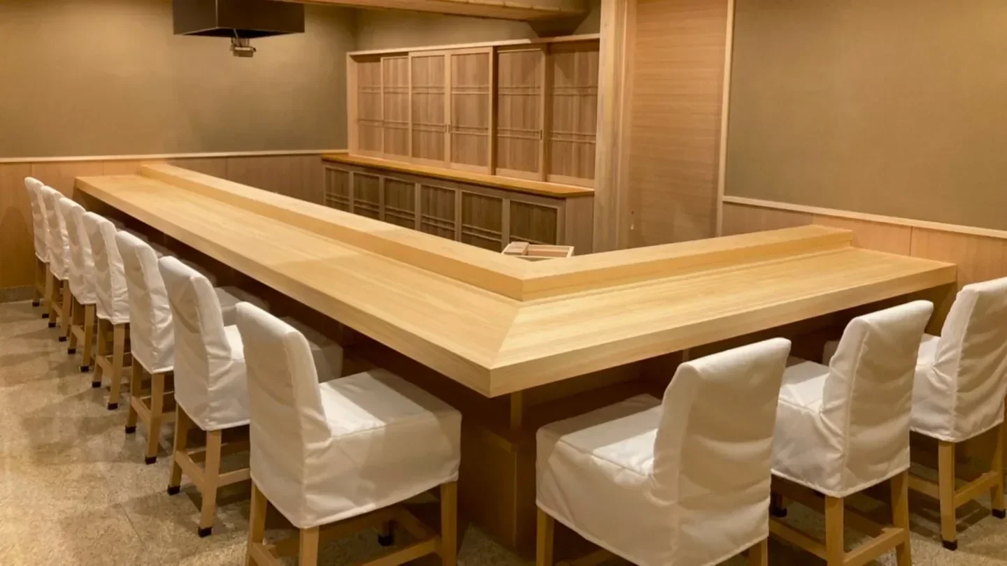 Interior of Ginza Kitagawa restaurant in Tokyo, featuring a minimalist wooden sushi bar.