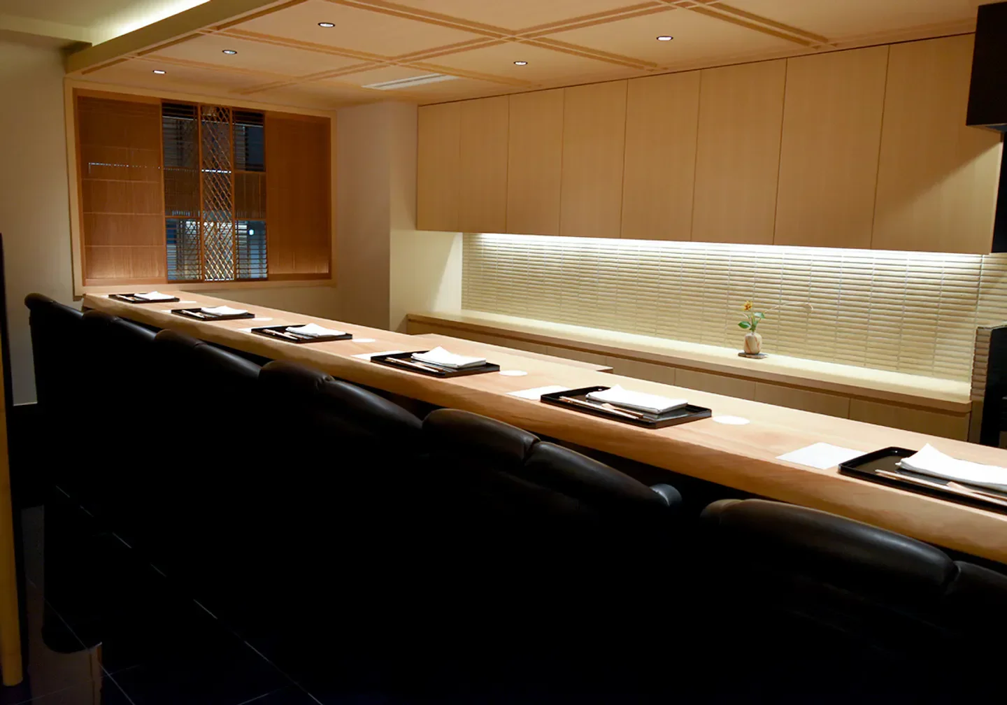 Interior of Ginza Kousui restaurant in Tokyo with sushi bar seating and wooden decor.