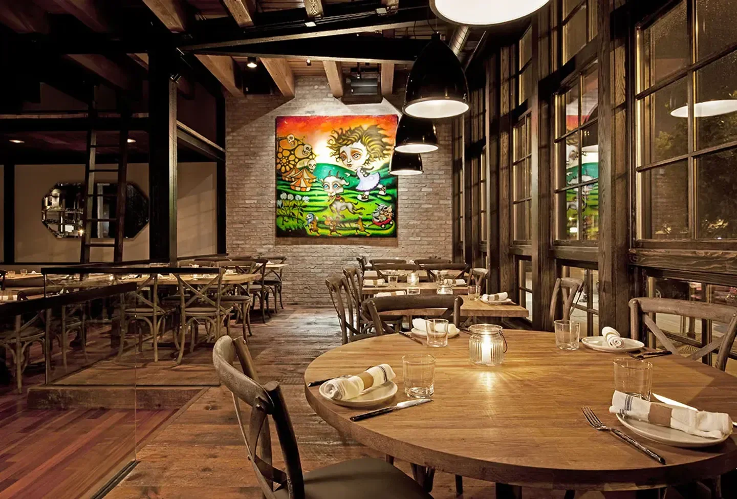 Interior of Girl & The Goat restaurant in Chicago, featuring artwork and dining tables.