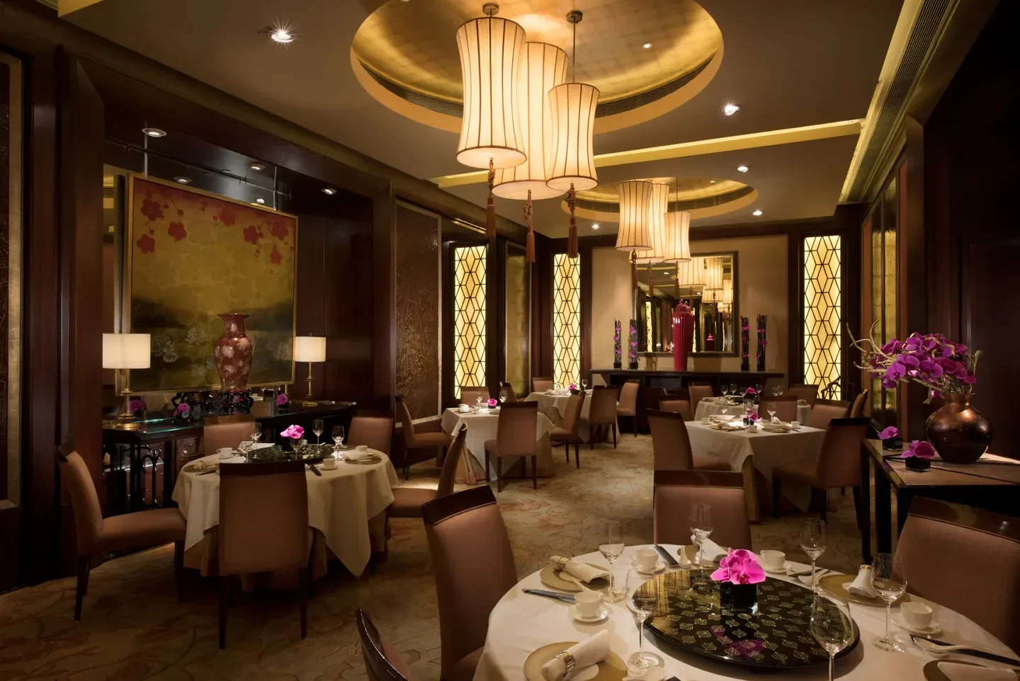 Elegant dining room at Golden Leaf restaurant in Hong Kong, with round tables and soft lighting.