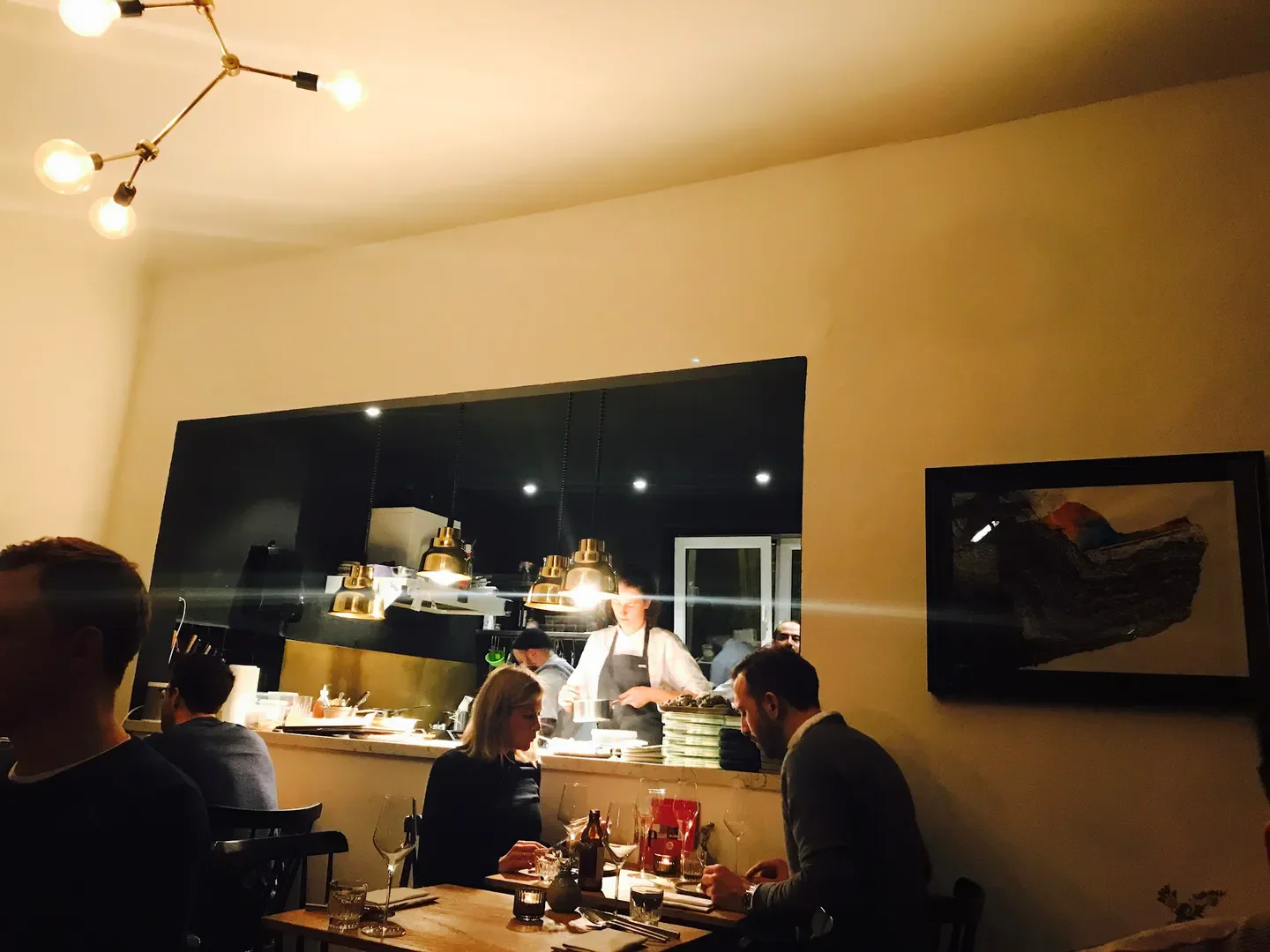 Cozy dining at haebel restaurant in Hamburg, featuring open kitchen and elegant ambiance.