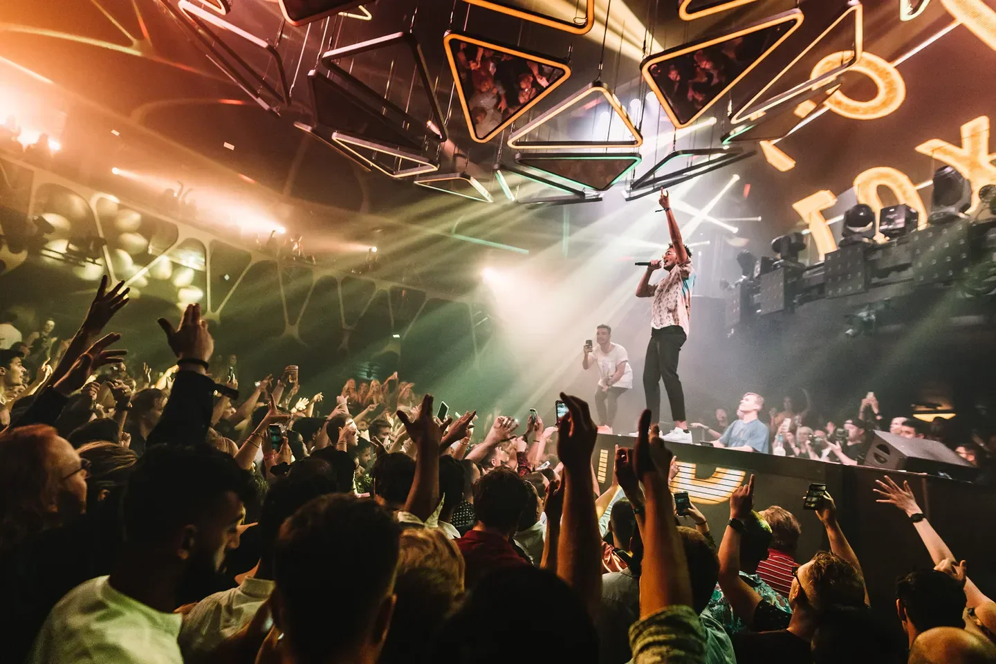 Energetic crowd at Hakkasan Las Vegas nightclub, with a performer on stage.