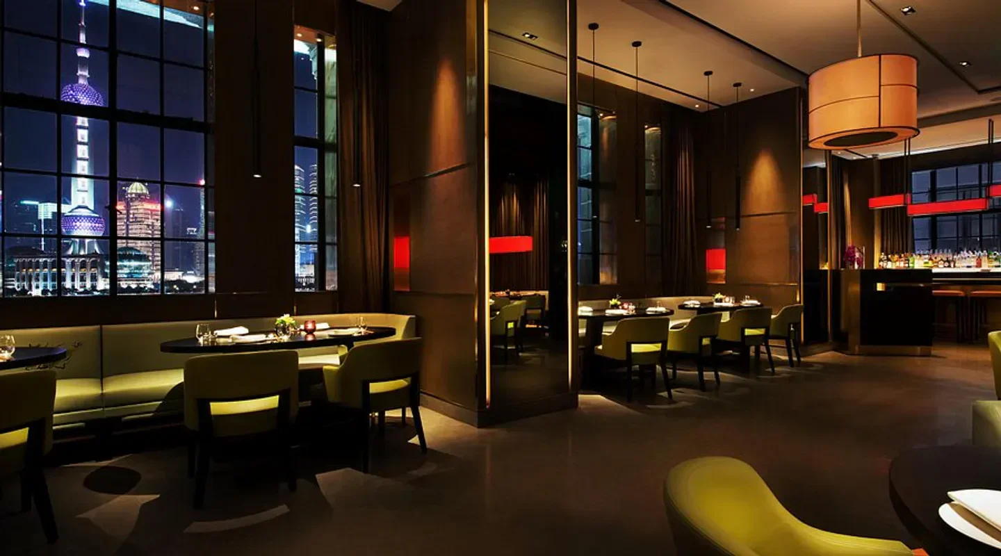 Hakkasan Shanghai's stylish interior with a view of the city's skyline at night.