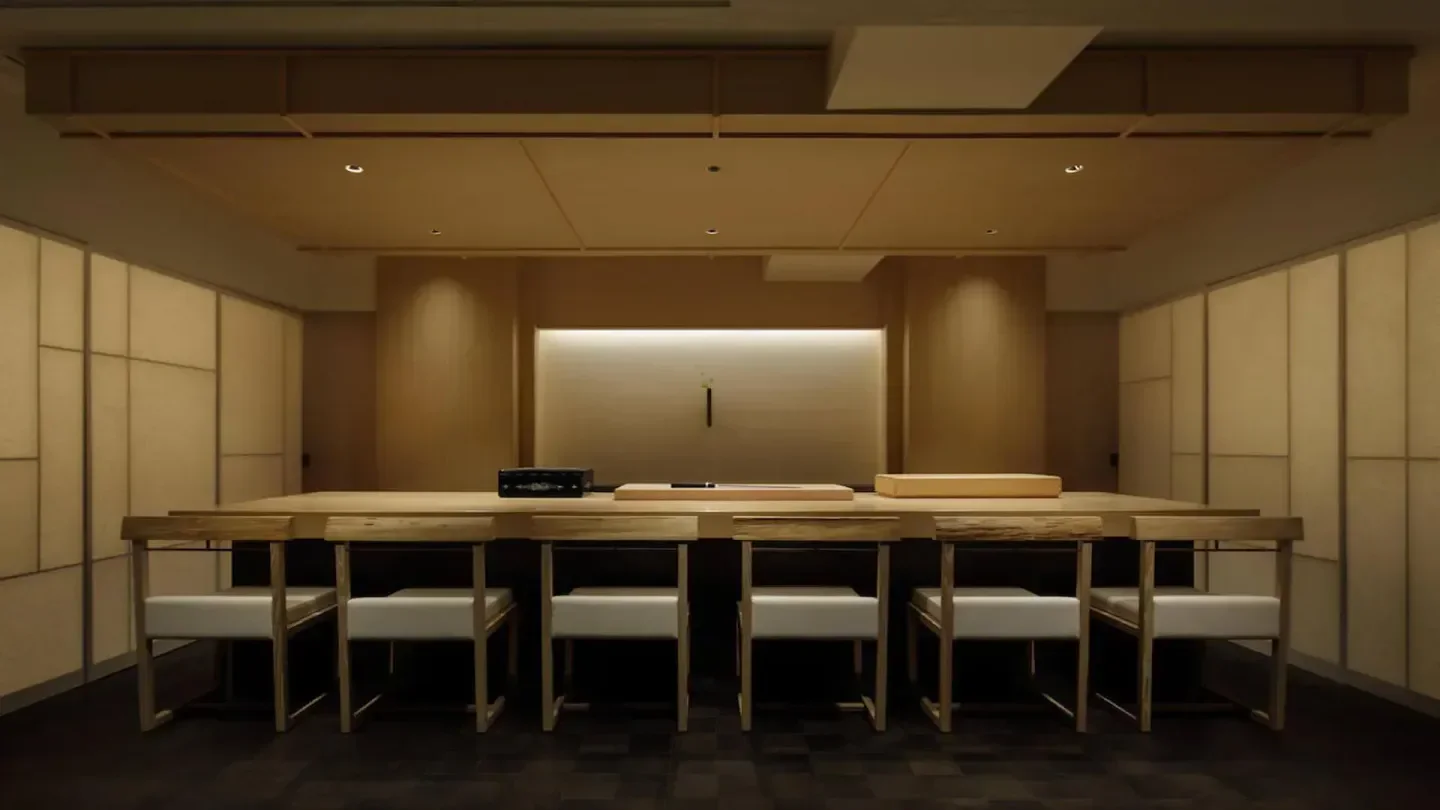 Minimalist interior of Hakkoku restaurant in Tokyo, showcasing a wooden sushi bar.