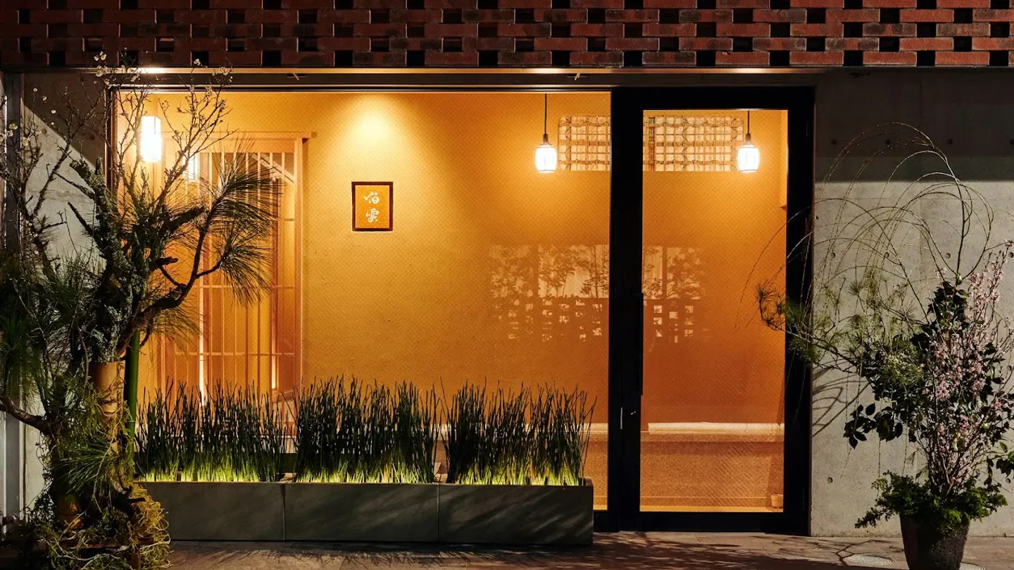 Entrance to Hakuun restaurant in Tokyo at night, with stylish warm lighting and decor.