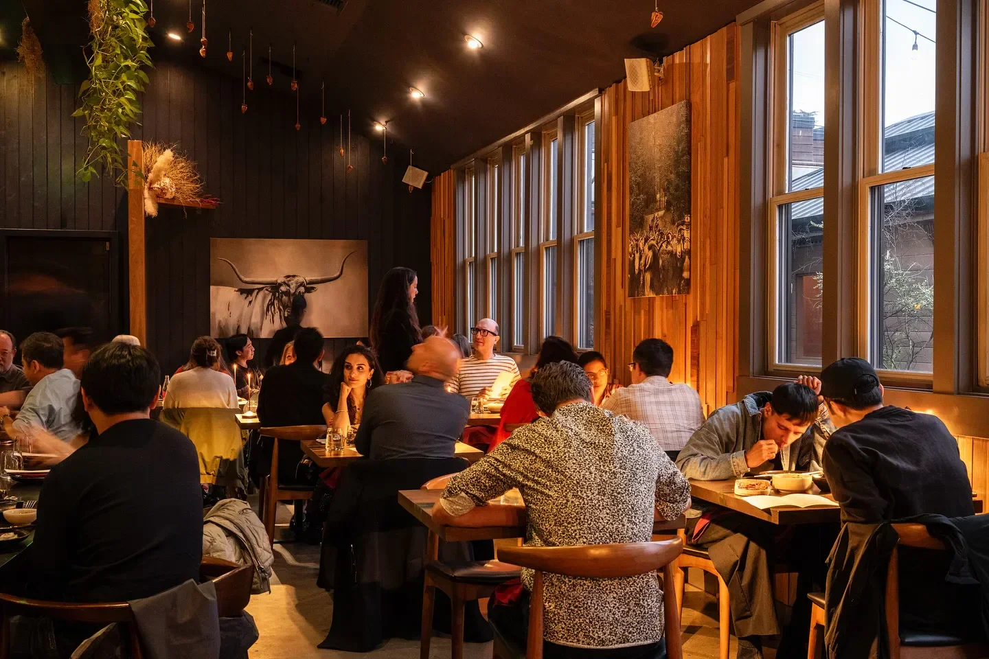 Cozy dining room at Hamdi restaurant in Seattle, with warm lighting and wooden accents.