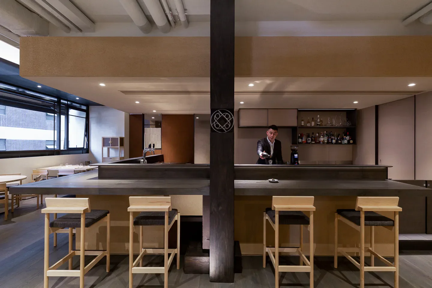 Stylish bar interior at Hansik Goo restaurant in Hong Kong, with a bartender serving.