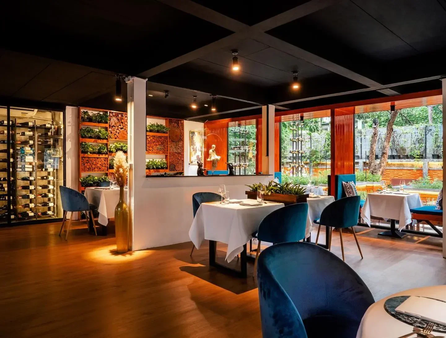 Interior of Haoma restaurant in Bangkok featuring stylish decor and lush greenery.