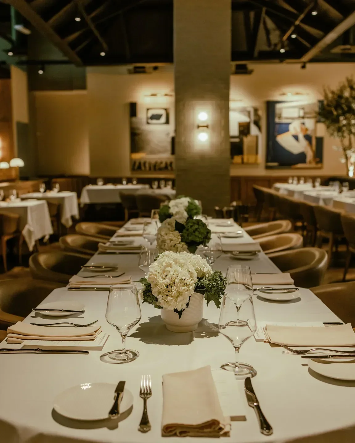 Elegant dining room at Harlo Steakhouse & Bar in Las Vegas, featuring floral centerpieces.