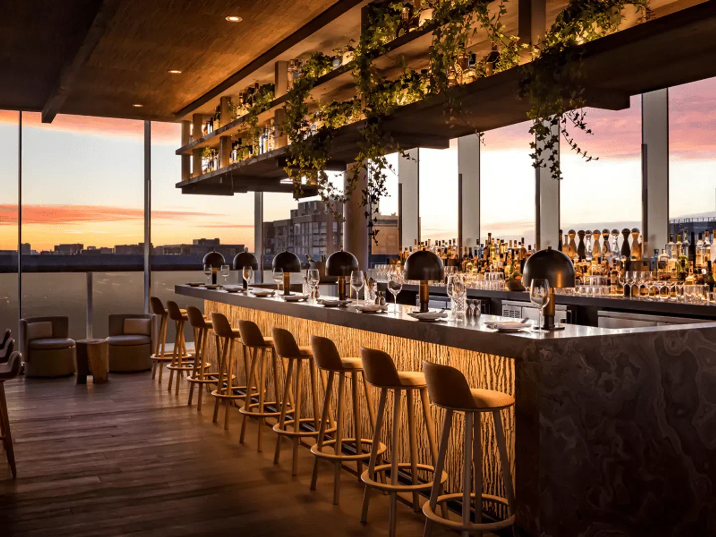 Stylish interior of Harriet's Rooftop bar in Toronto, with sunset views and bar stools.