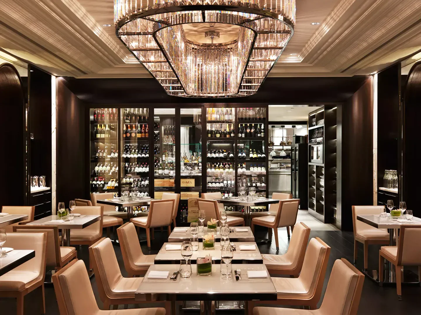 Elegant dining room interior at Hawksworth Restaurant in Vancouver, with wine display and crystal chandelier.