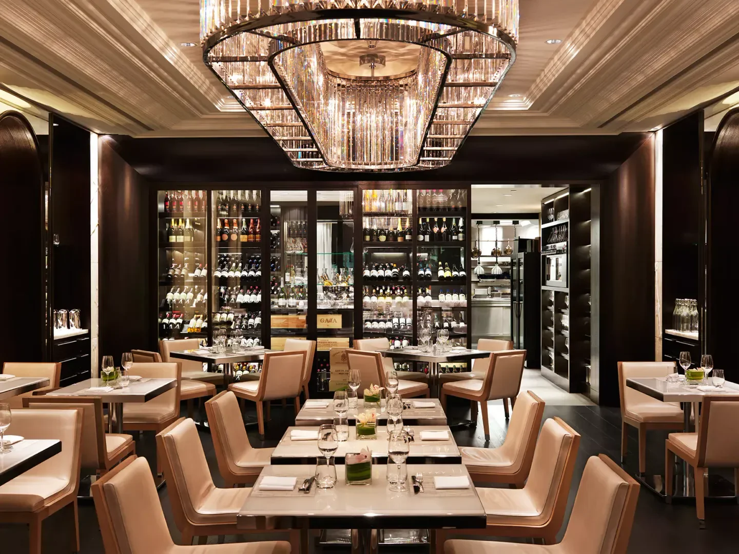 Elegant dining room interior at Hawksworth Restaurant in Vancouver, with wine display and crystal chandelier.