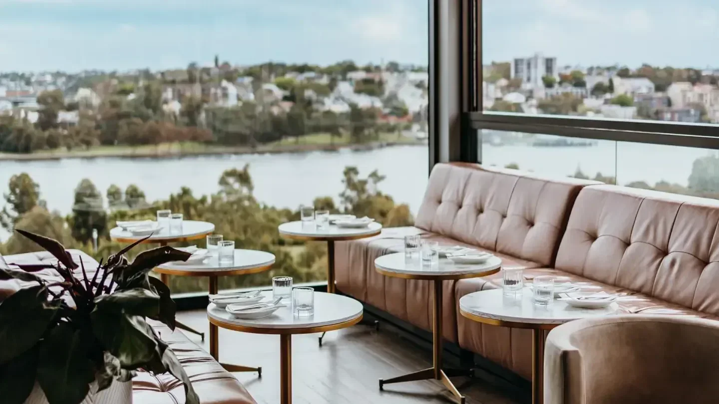 Restaurant seating with a view at Henry Deane, Sydney, overlooking the water.