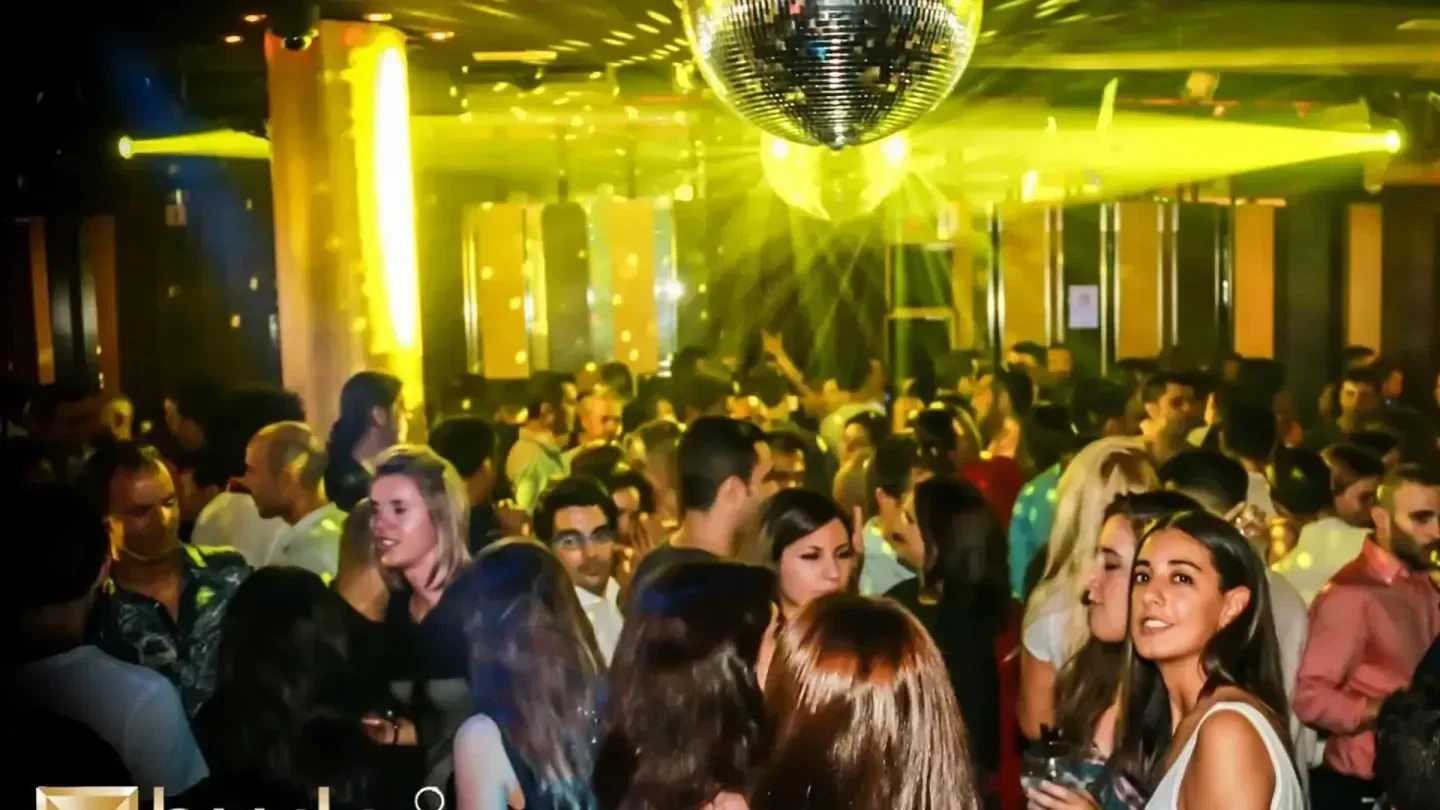 Energetic crowd partying at Hyde Club in Barcelona, under disco ball lights