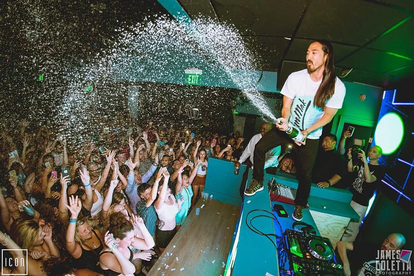 Icon nightclub in Boston: DJ spraying champagne over a lively crowd.
