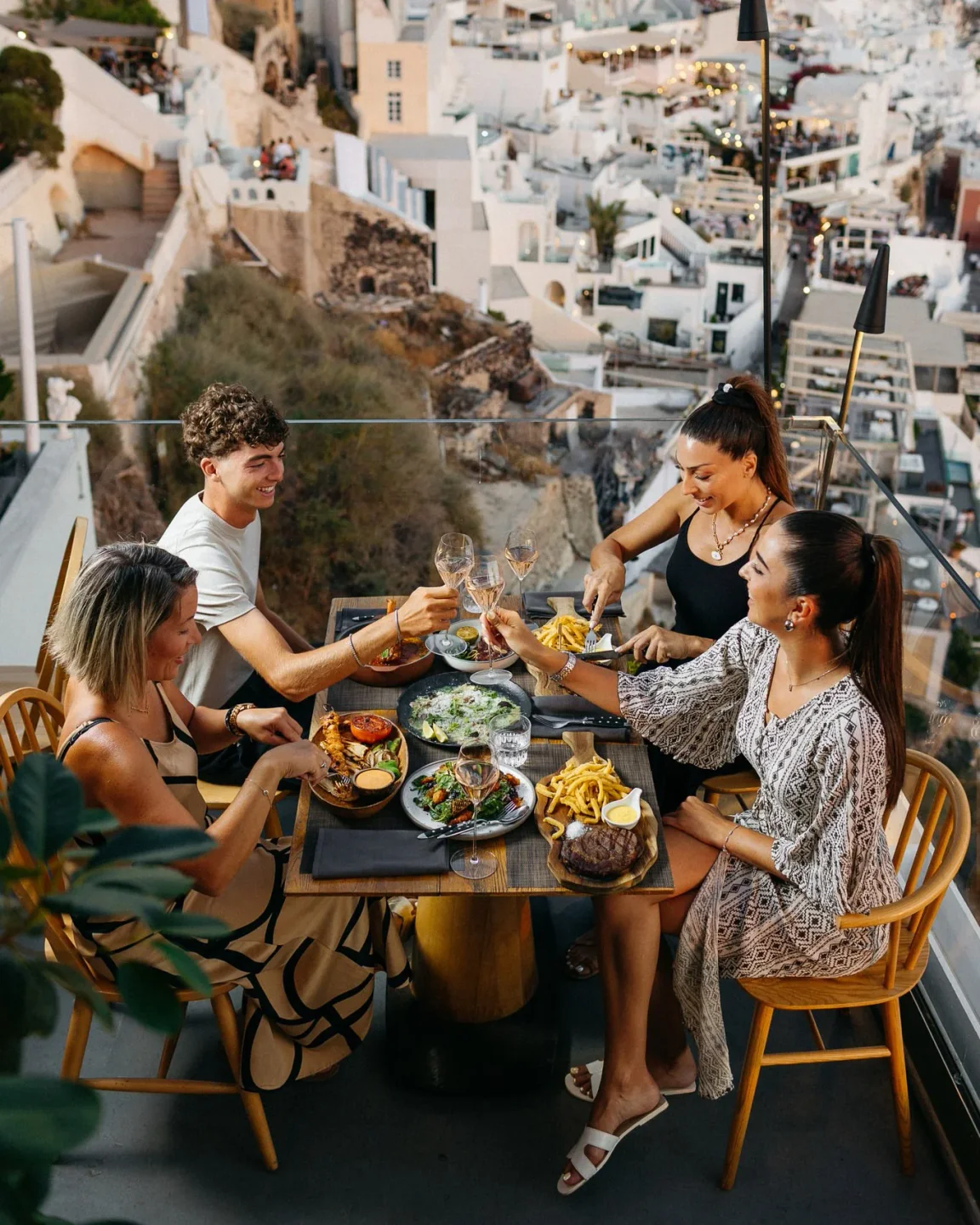 Friends enjoy a meal with a view of white buildings at Idol Restaurant Bar in the city.