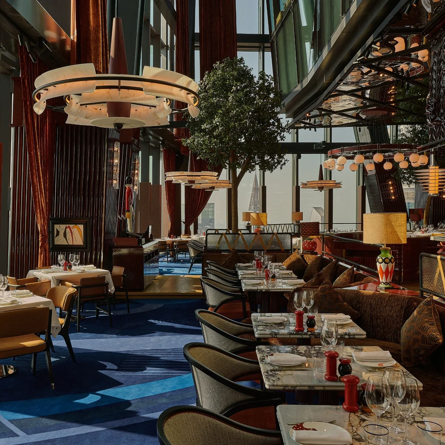 Il Gattopardo restaurant interior featuring elegant seating, marble tables, and city views.