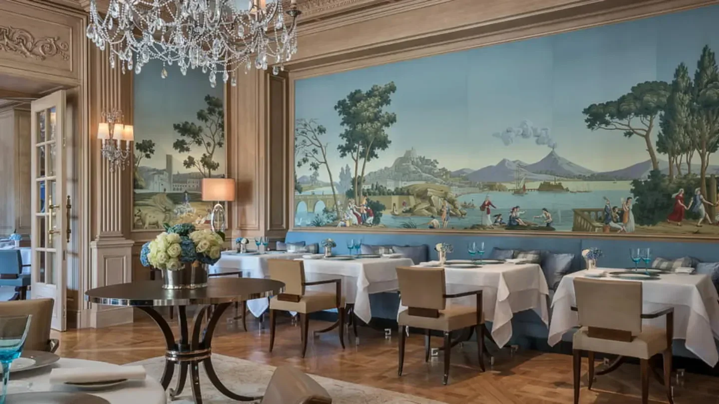 Elegant dining room at Il Lago Geneva, featuring beautiful artwork and crystal chandelier.