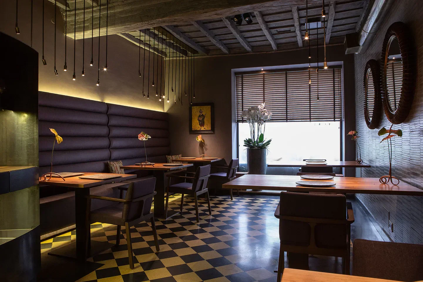 Stylish interior of Il Pagliaccio restaurant in Rome with dim lighting and checkered floors.