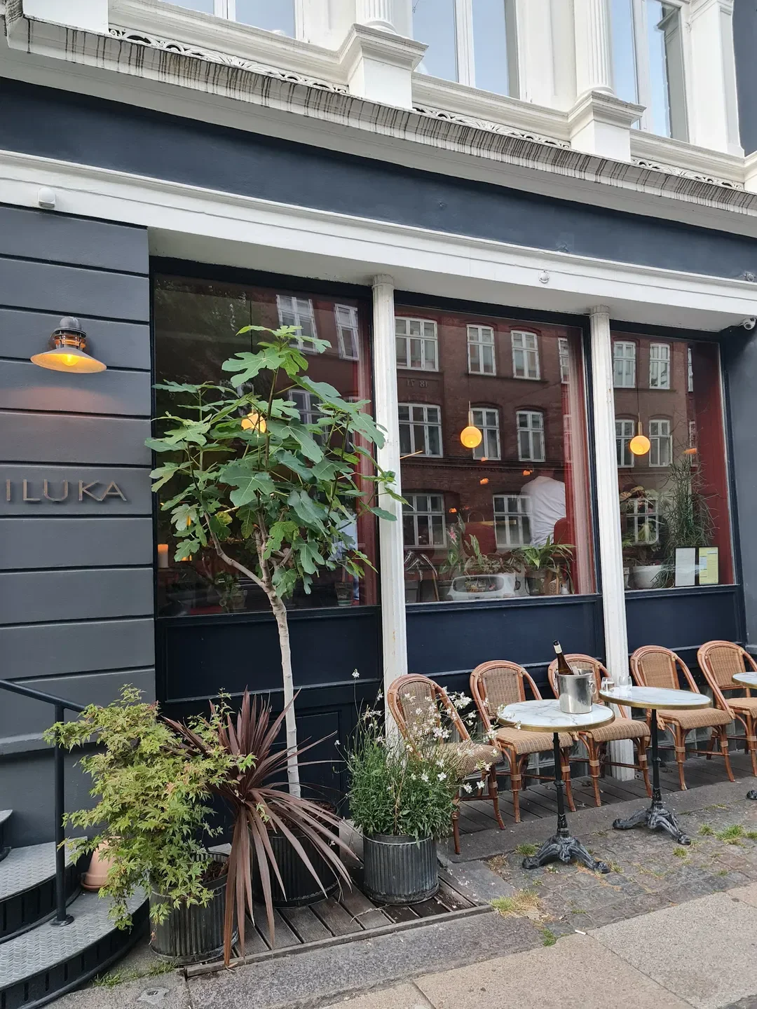 Exterior of Iluka restaurant in Copenhagen, featuring outdoor seating and stylish facade.