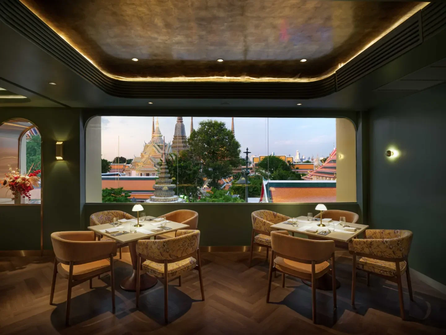 Interior of INDDEE restaurant in Bangkok with view of temples and stylish seating.