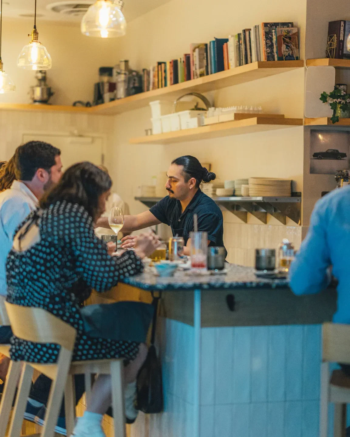 Cozy bar scene at Itamae AO in Miami, with guests enjoying drinks and atmosphere.