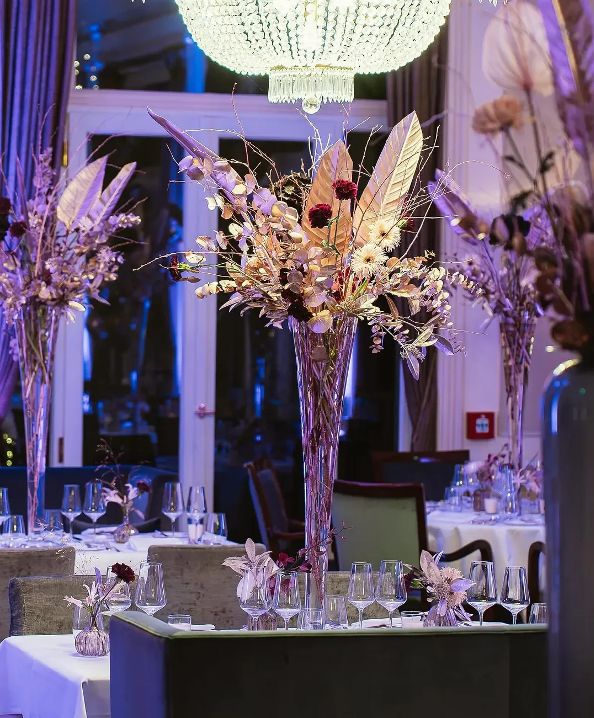 Elegant dining at Jacob's Restaurant in Hamburg, featuring floral arrangements and chandeliers.