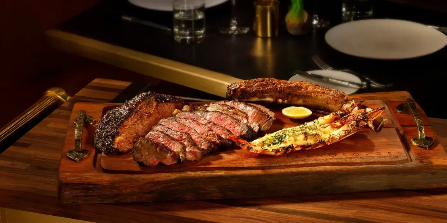 Delicious steak and lobster at Jean Georges Steakhouse in Las Vegas, on a wooden platter.