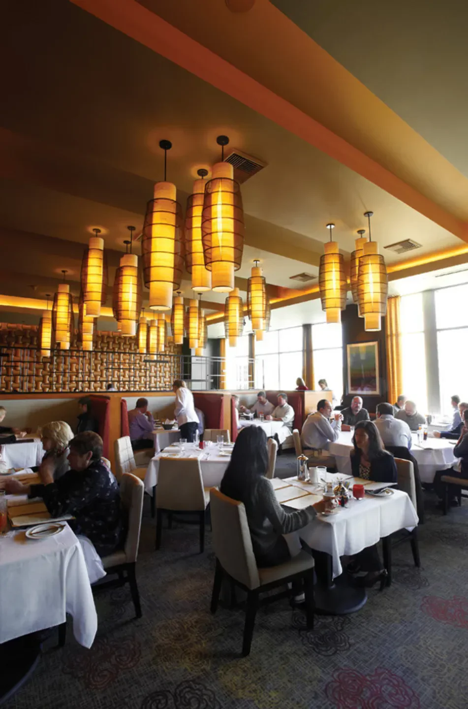 Interior of John Howie Steak in Seattle, showing tables, diners, and stylish lighting.