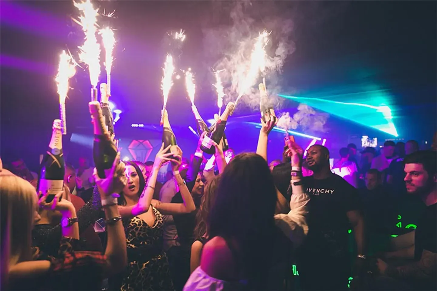 Celebration at Jolie Club in Rome, with champagne and sparklers at a lively nightclub.