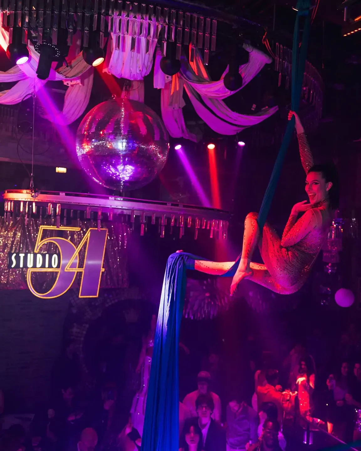 Aerial performer at Joy District in Chicago, with disco ball and nightclub crowd.