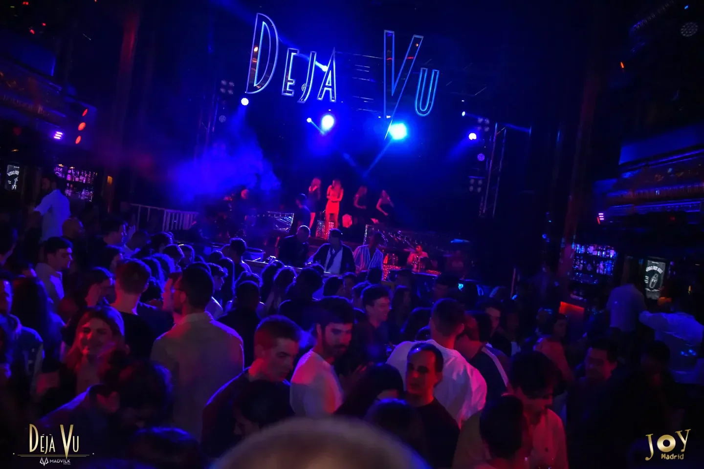 Energetic crowd at Joy Eslava nightclub in Madrid, under neon lights during a concert.