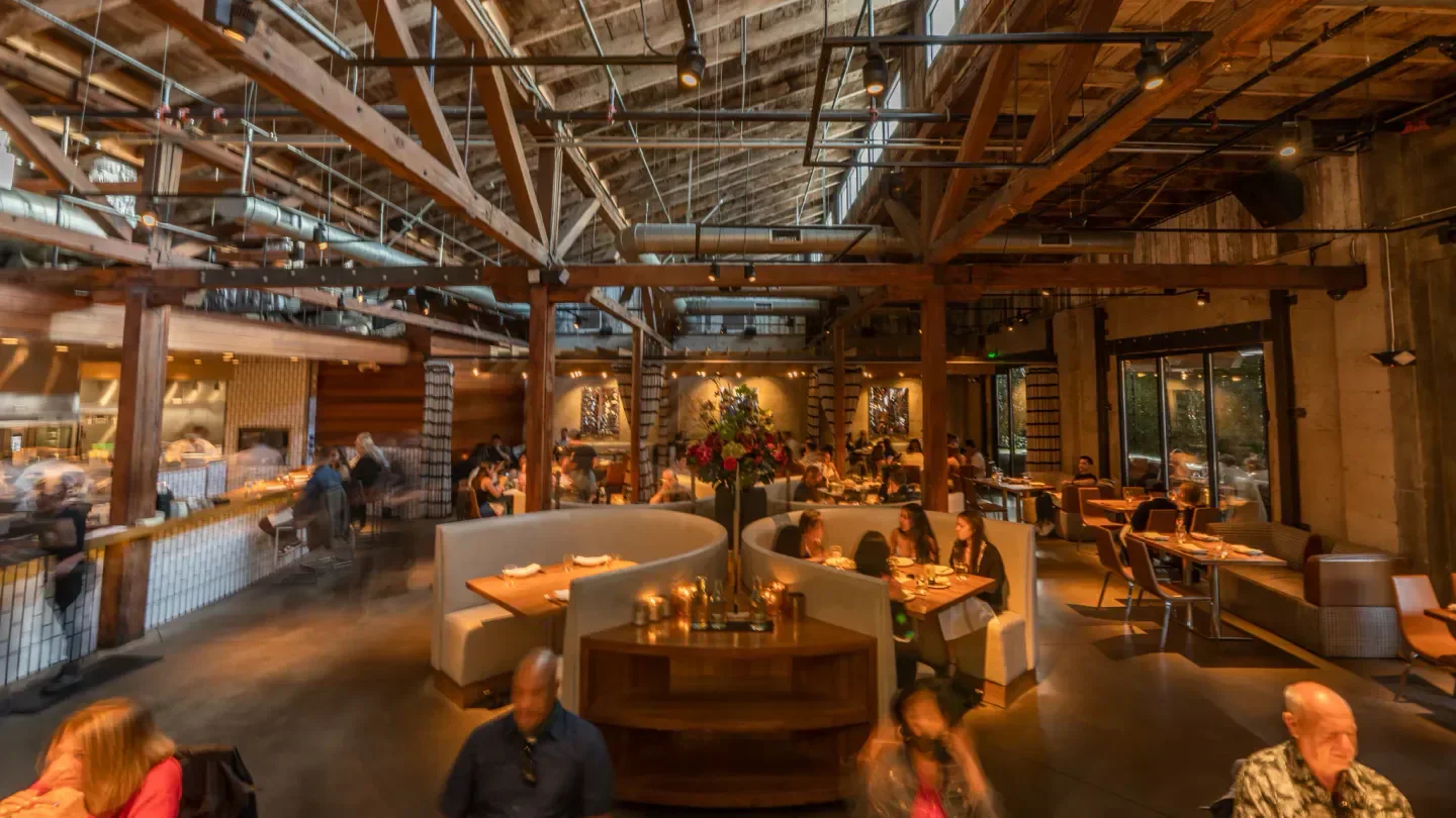 Interior of Juniper & Ivy restaurant in San Diego, featuring wood beams and dining areas.