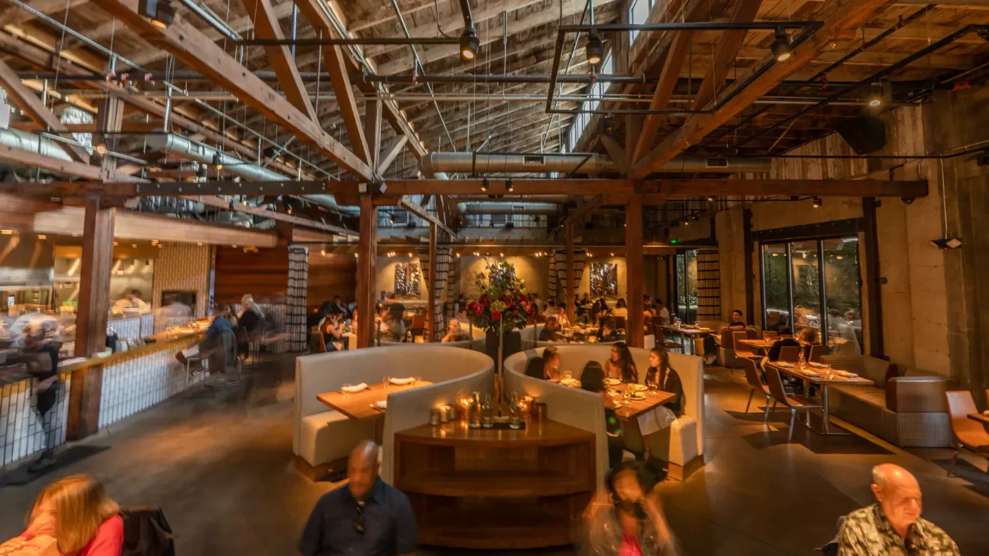 Interior of Juniper & Ivy restaurant in San Diego, featuring wood beams and dining areas.