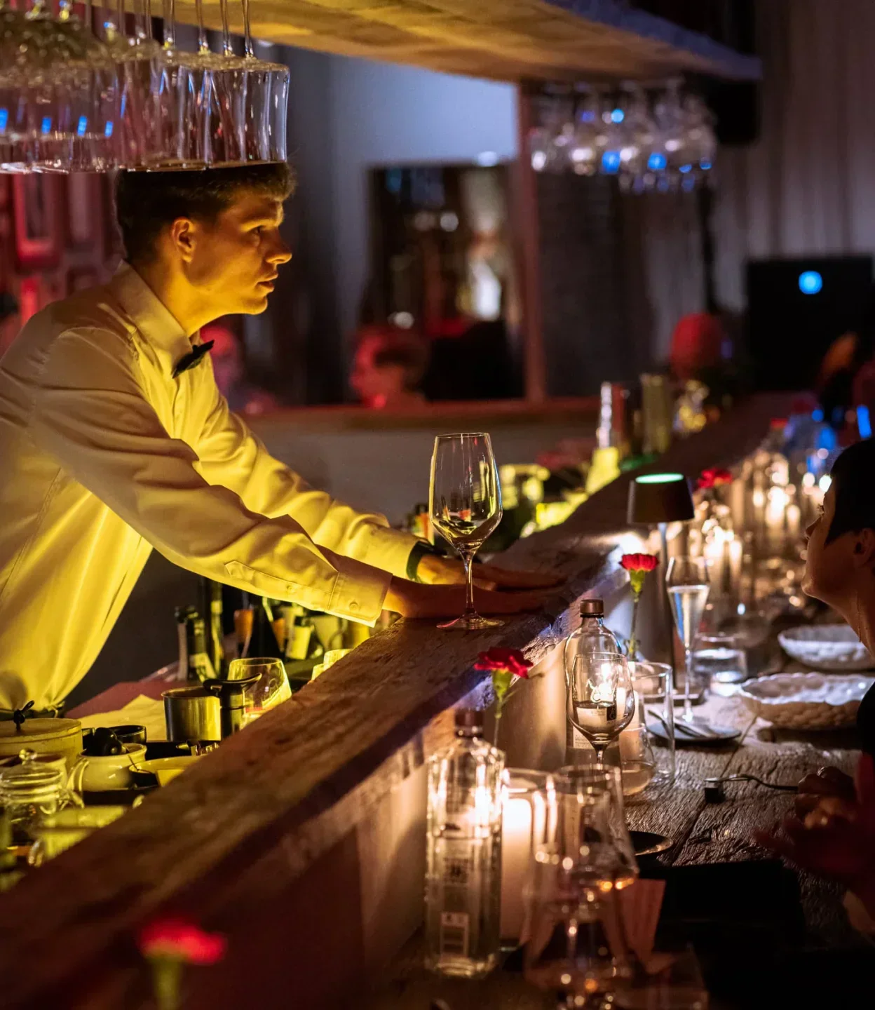 Waiter serving at Kaiamo restaurant in Bucharest, showcasing elegant interior and table setting.