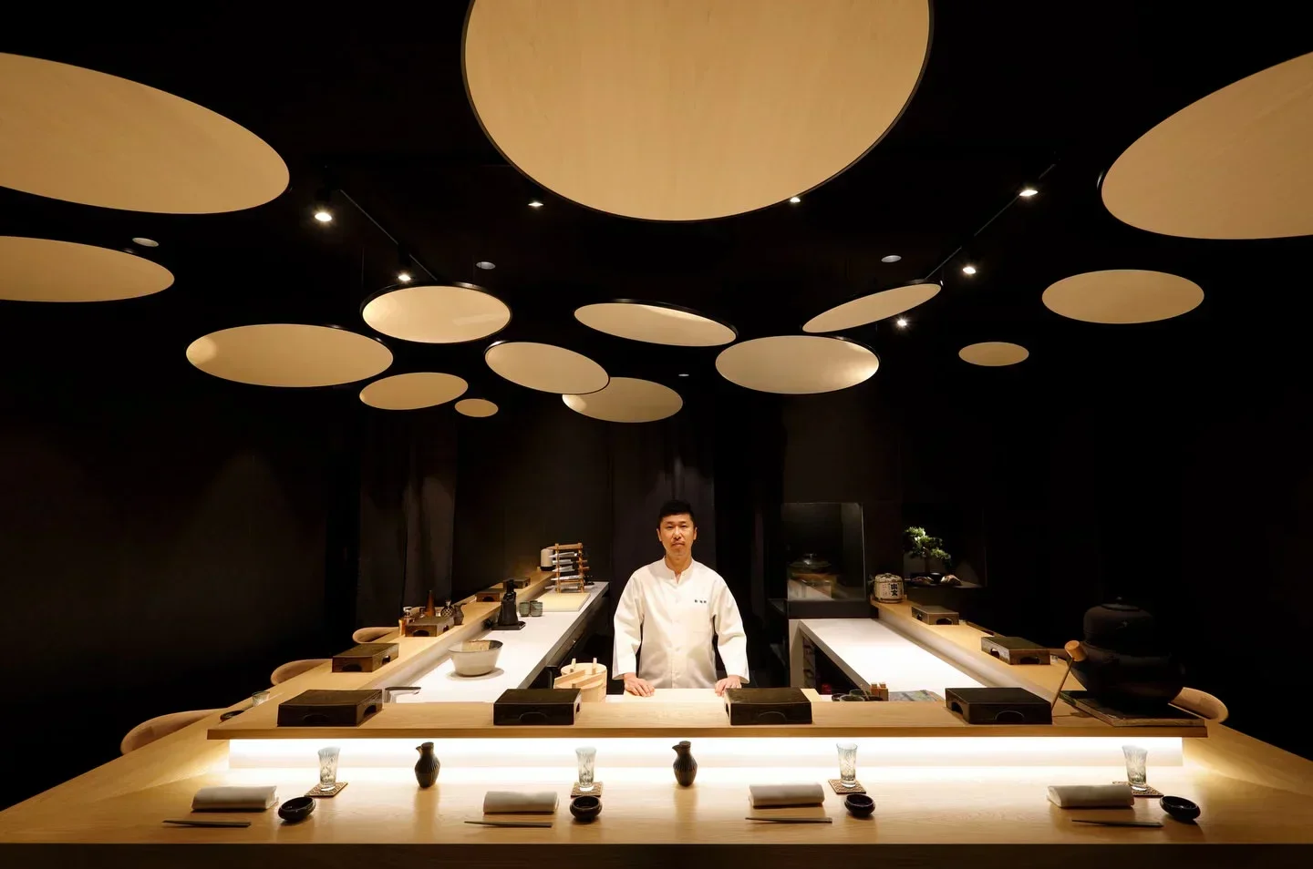 Chef at Kaido Sushi Bar in Valencia, Spain. Stylish interior with unique ceiling design.