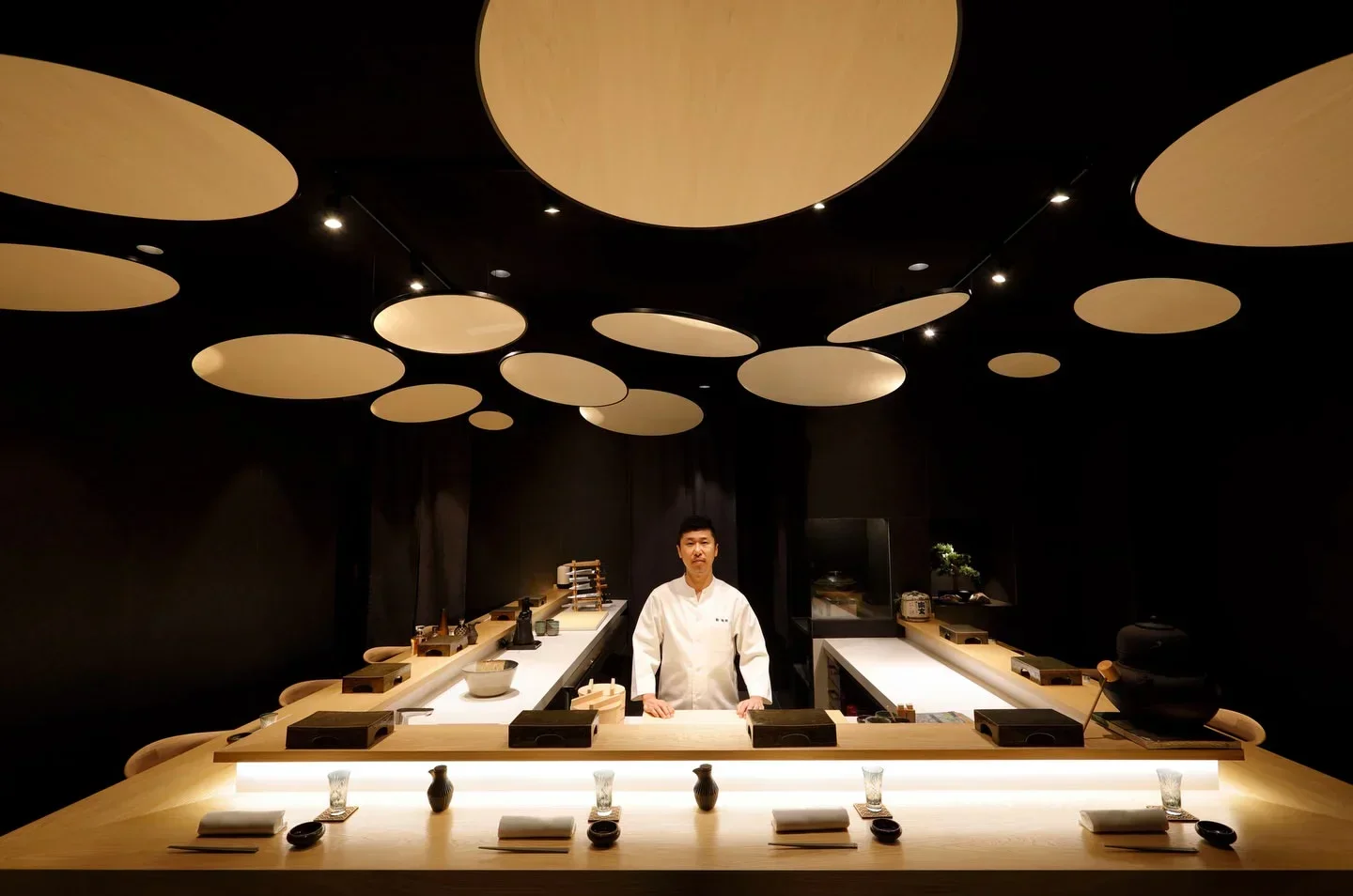 Chef at Kaido Sushi Bar in Valencia, Spain. Stylish interior with unique ceiling design.