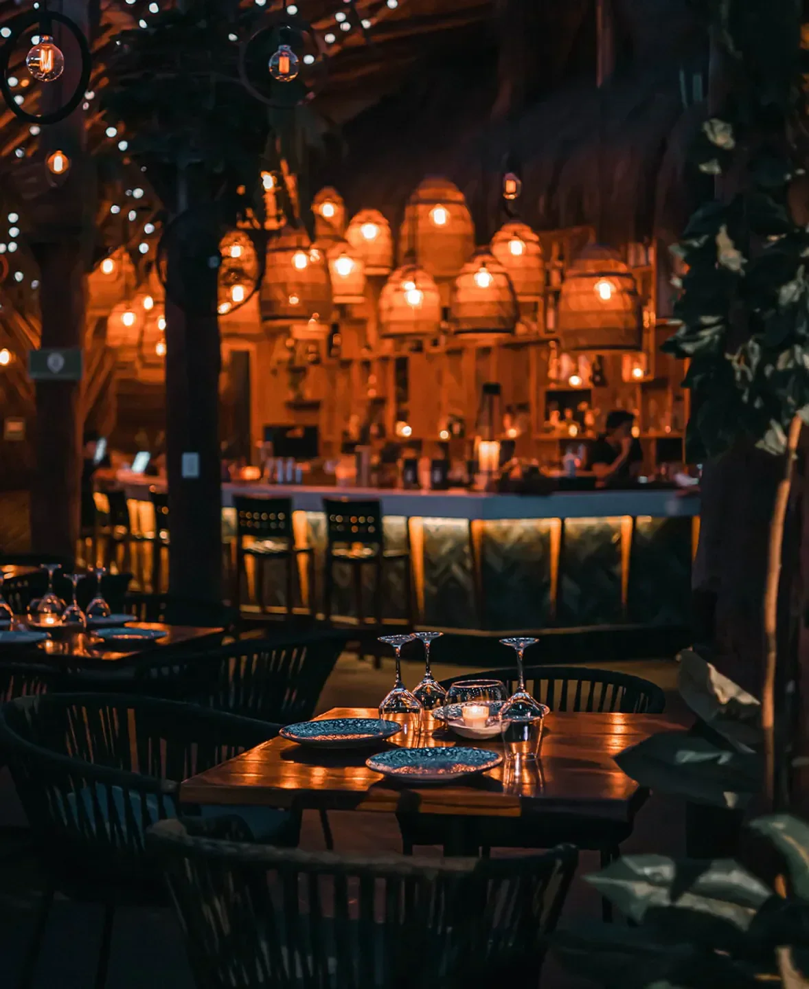 Cozy dining area at Karma restaurant in Tulum, illuminated with warm lighting.