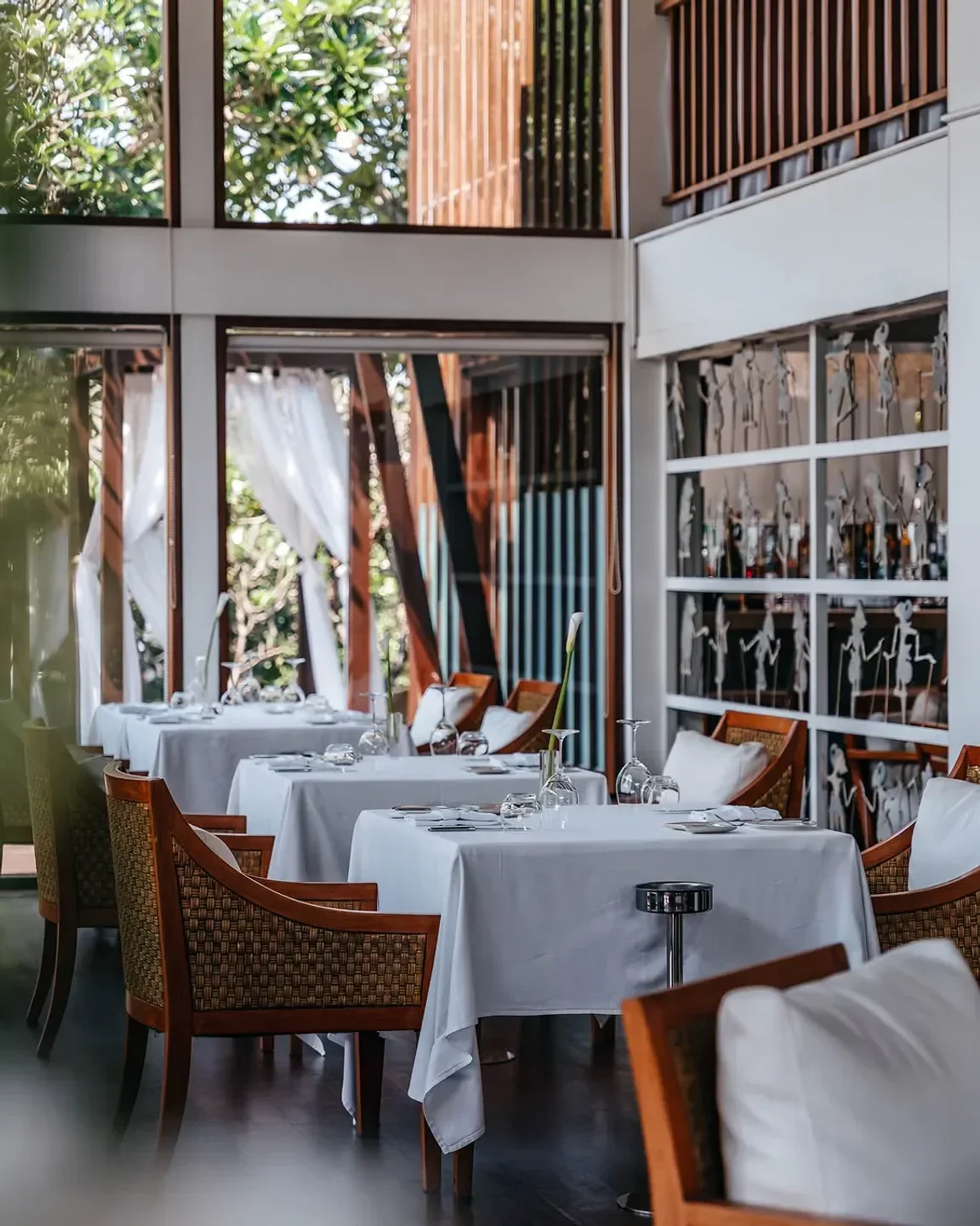 Elegant dining tables at Kayuputi Restaurant in Bali, Indonesia with a bright interior.