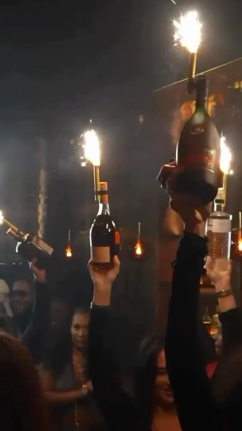 People celebrating at Keys nightclub with sparklers on bottles, creating a festive atmosphere in the city.