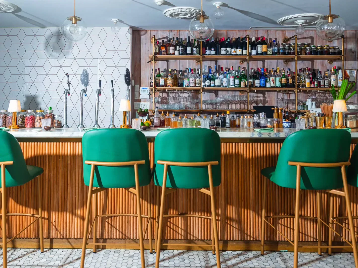 Interior of KIIN restaurant in Toronto, with green bar stools and stylish design.