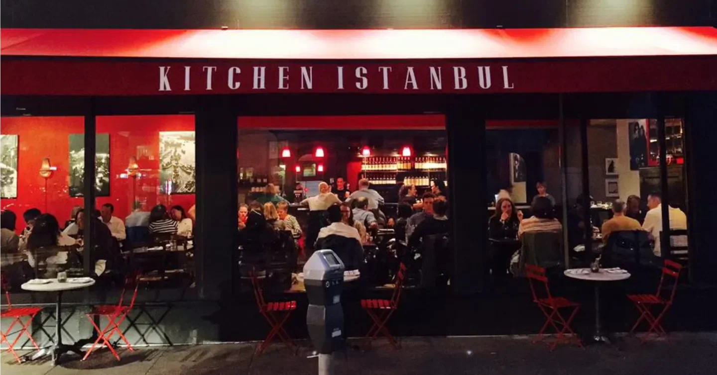 Exterior of Kitchen Istanbul restaurant in San Francisco with patrons dining inside.