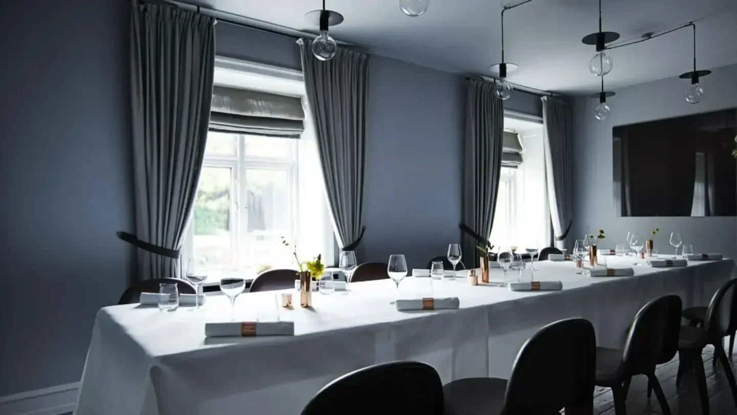 Elegant dining room at Kokkeriet in Copenhagen, featuring long table setting.