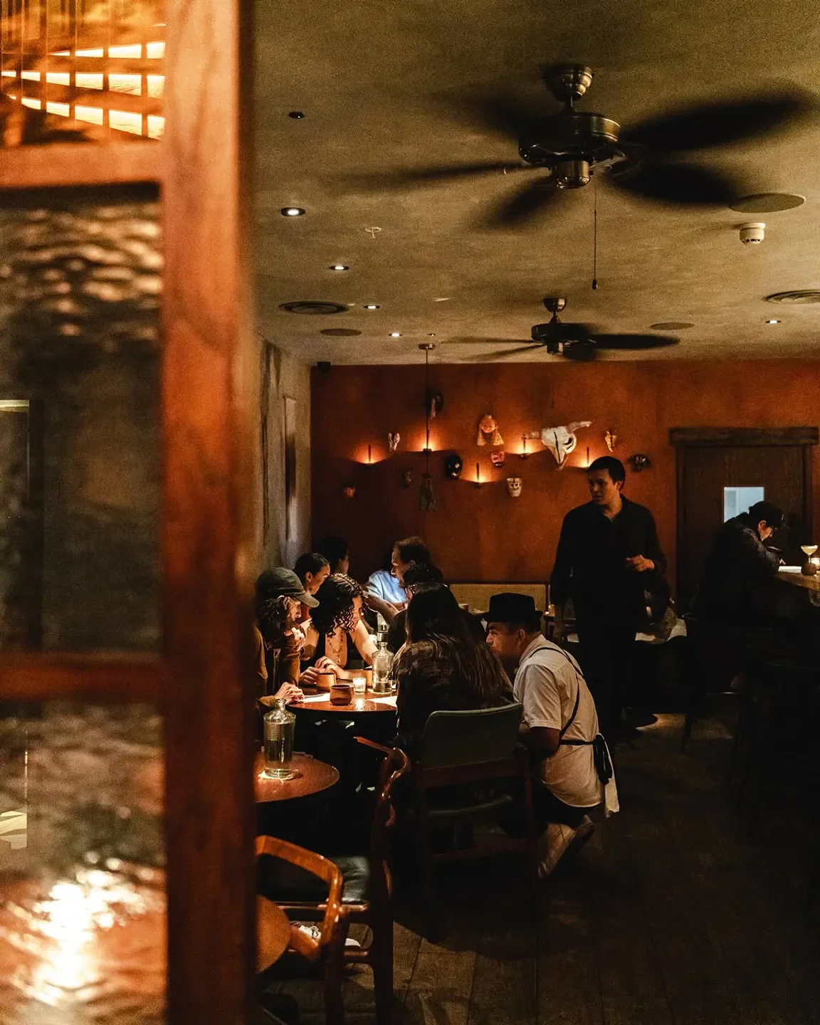 Cozy dining scene at KOL London restaurant, featuring a chef attending guests.
