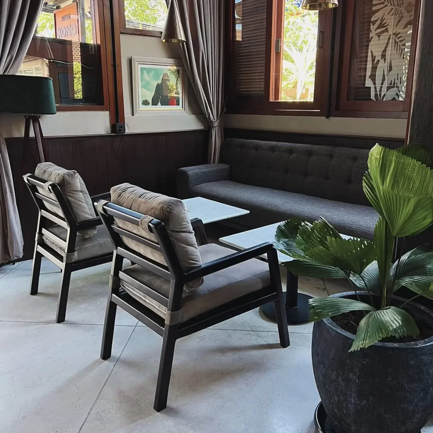 Cozy interior of Kong restaurant in Bali, with comfortable seating and a potted plant.
