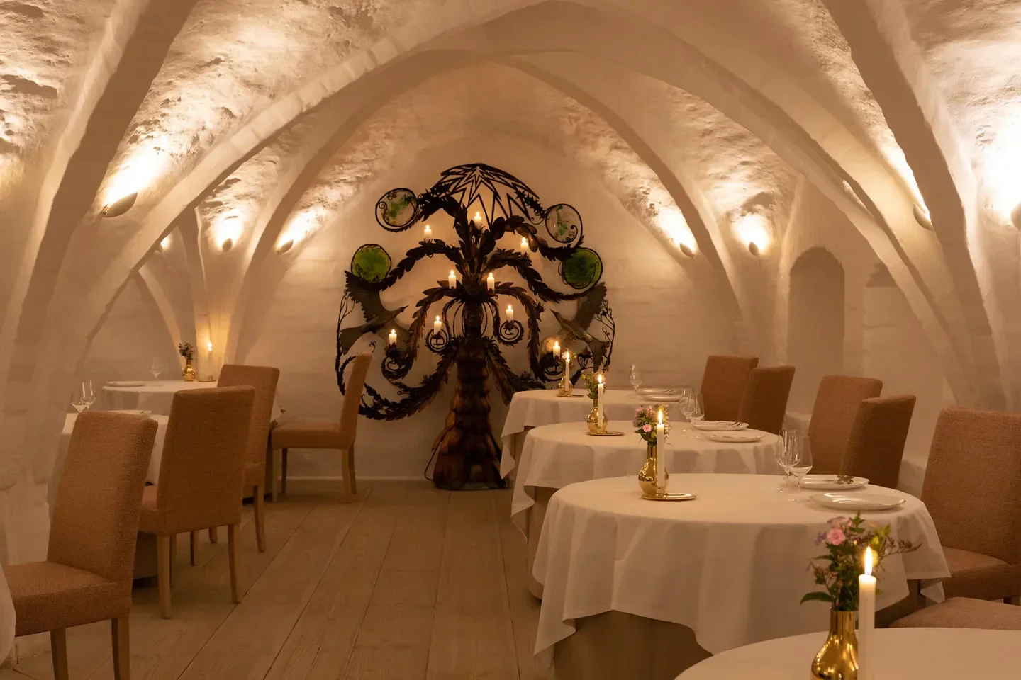Elegant dining room interior at Kong Hans Kælder in Copenhagen, with candlelit tables.